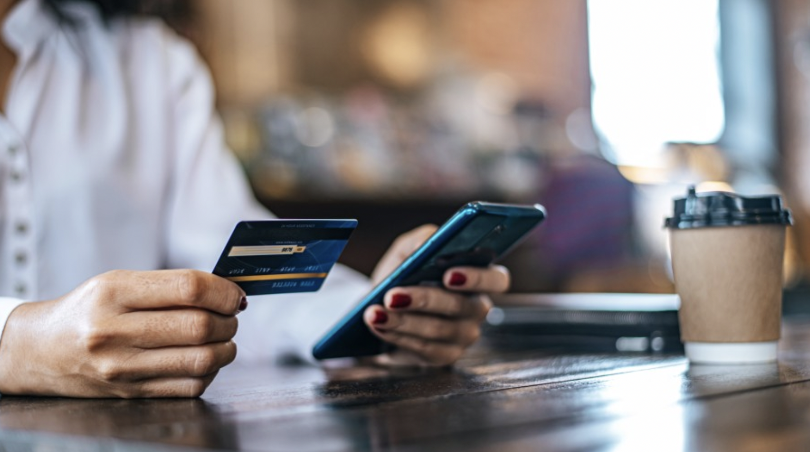 Image of a woman paying for her coffee.